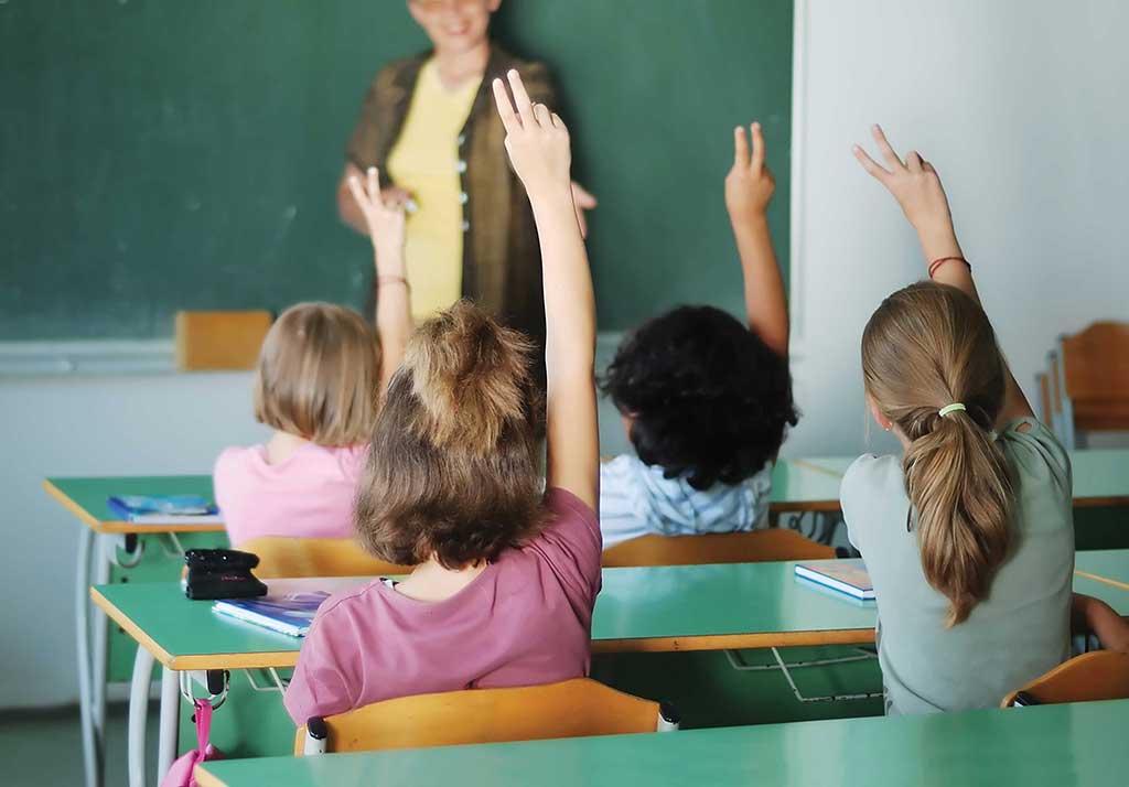 Kids raising hands in school